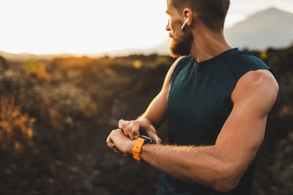 A Fitness Enthusiast Uses Smart Watch While Exercising Outdoors
