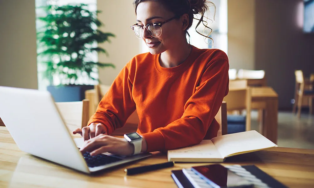 A Lady Wearing A Smart Watch Is Working on Her Computer